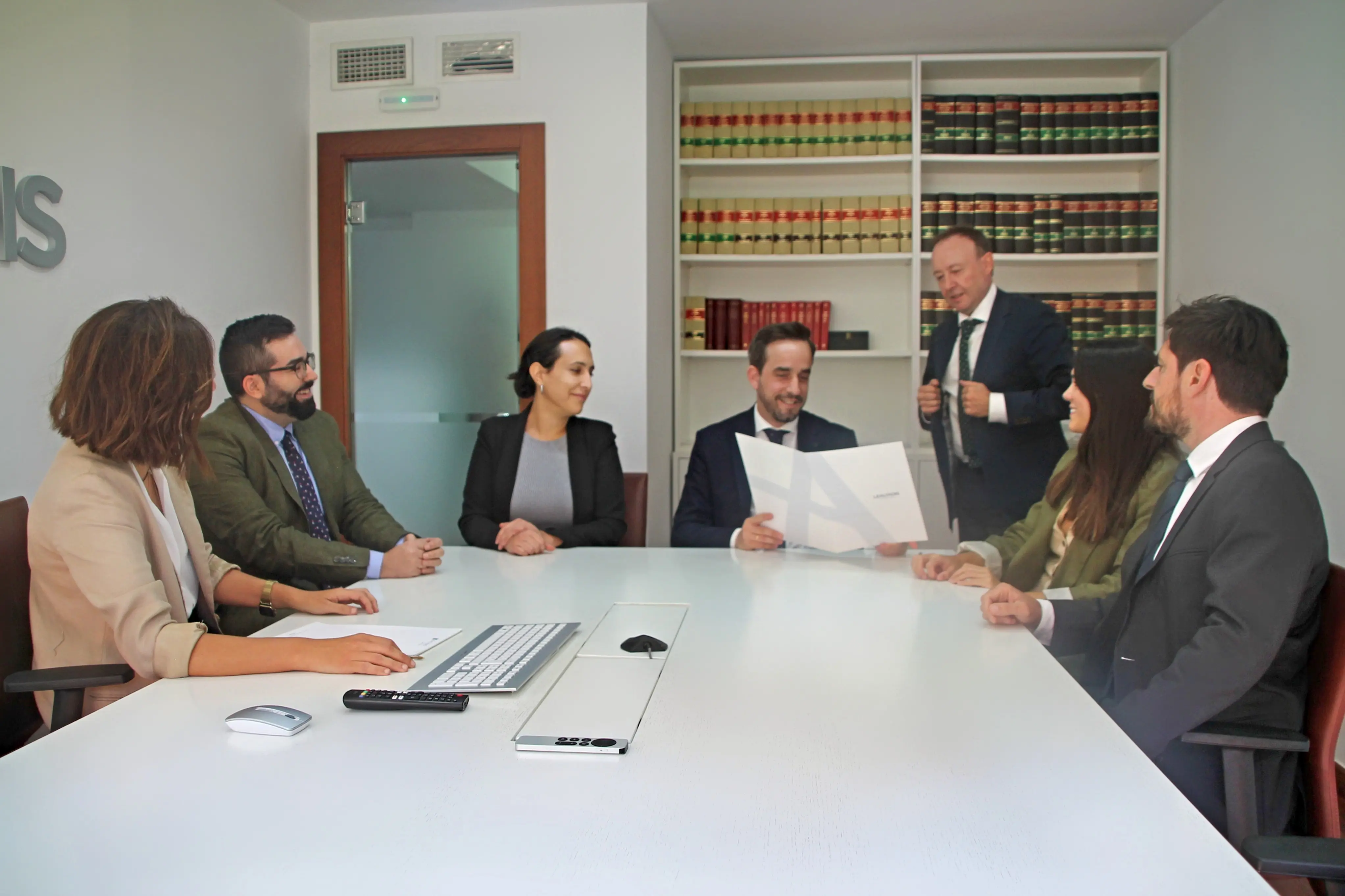 Retrato del equipo de abogados de Lealtadis Abogados en la sala de juntas.